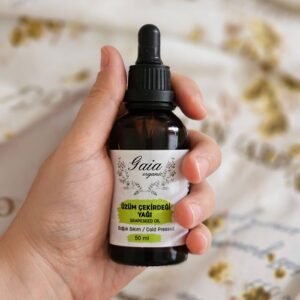 Close-up of a hand holding a bottle of Gaia organic grapeseed oil, perfect for skincare.